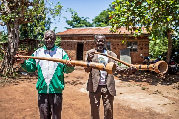 Musician James Lugolole (left) and a peer hold Bigwala instruments.